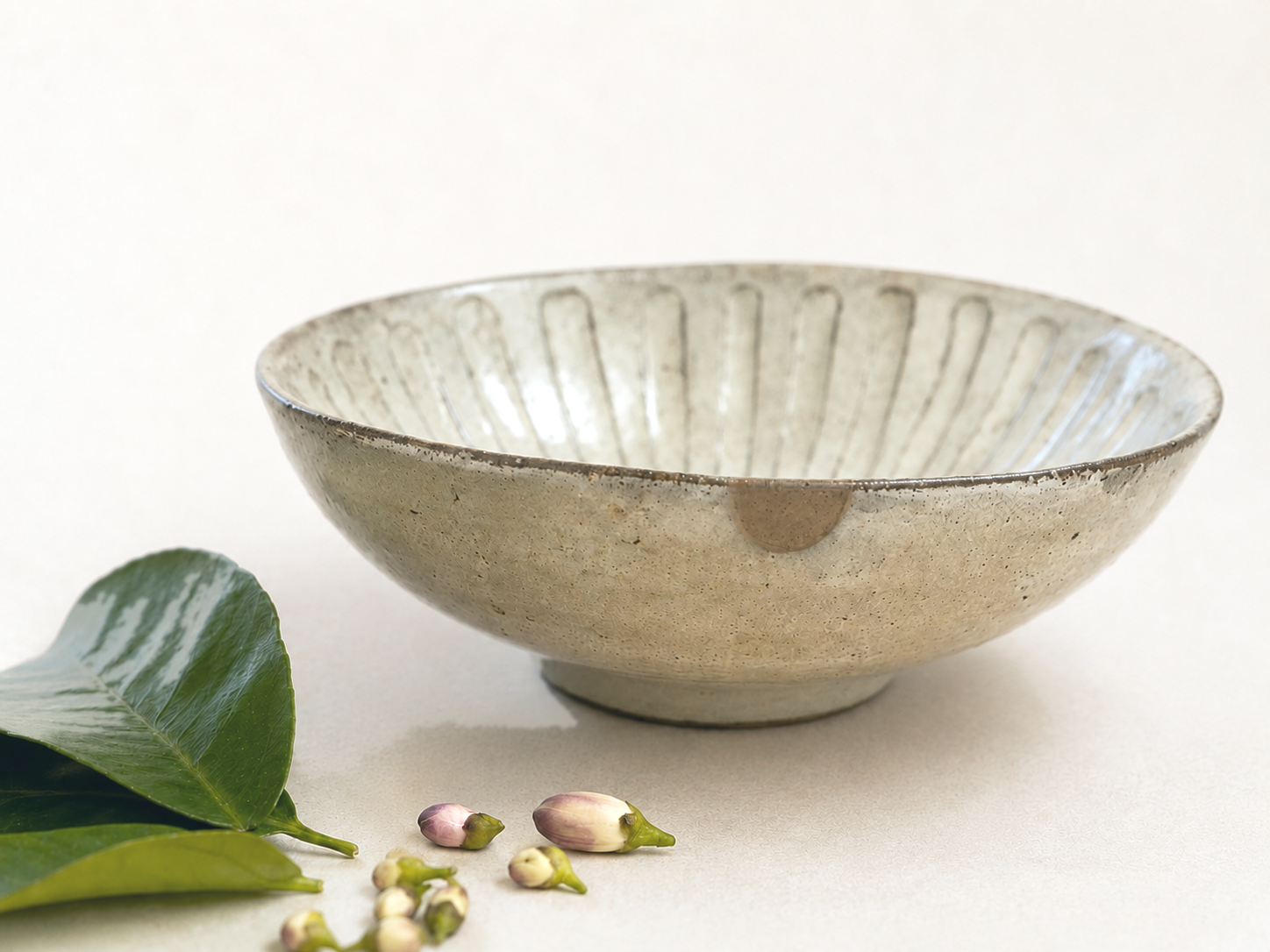 灰釉の浅鉢。縁の小さな欠けを本漆金継ぎで繕う（Atelier KYM）
